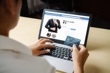 Genç adam online alışveriş için kredi kartı kullanıyor.