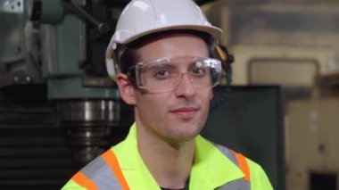 Genç bir fabrika işçisi ya da mühendis fabrikada portreyi kapatıyor.