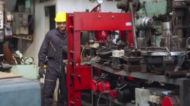 Genç bir fabrika işçisi ya da mühendis fabrikada portreyi kapatıyor.