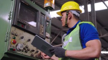 Fabrika atölyesinde makine kullanan akıllı bir fabrika işçisi