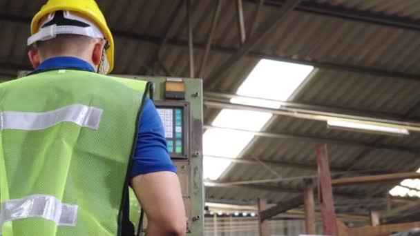 Groep fabrieksarbeiders die machineapparatuur gebruiken in fabriekswerkplaats — Stockvideo