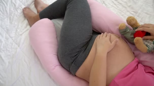 Happy pregnant woman sleeping on bed in bedroom.