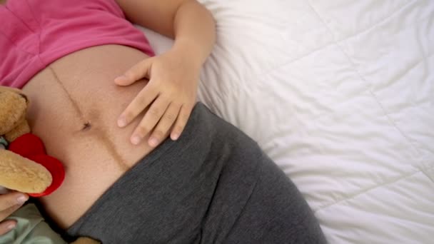 Lycklig gravid kvinna sover på sängen i sovrummet. — Stockvideo