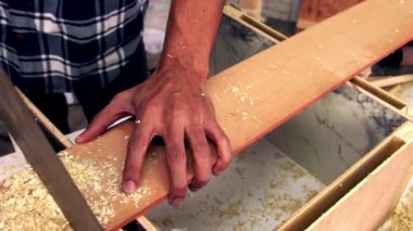 Marangoz atölyede ahşap işçiliği yapıyor.