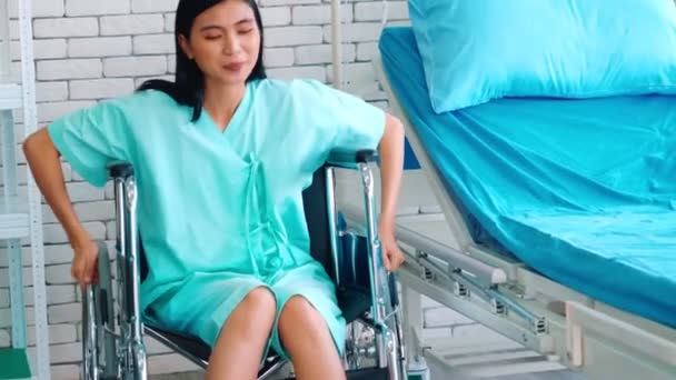 Young happy Asian woman on wheelchair in a hospital ward — Stock Video