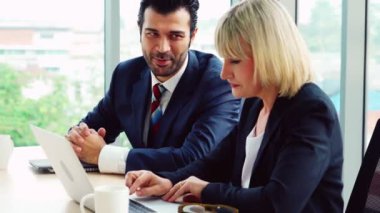 İki iş adamı ofiste proje stratejisi hakkında konuşuyor