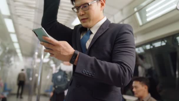 Businessman using mobile phone on public train — Stock Video