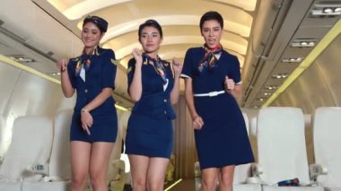 Kabin ekibi uçakta neşeyle dans ediyor.