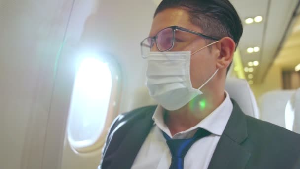 Ταξιδιώτης με μάσκα προσώπου ενώ ταξιδεύει με εμπορικό αεροπλάνο . — Αρχείο Βίντεο