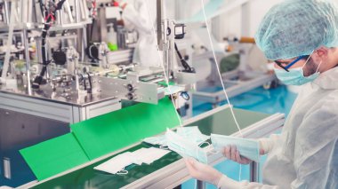 Modern fabrikada yüz maskesi üretim hattı