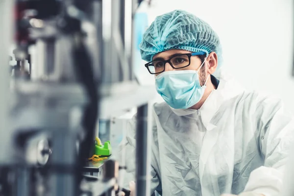 Production line worker with face mask working in electronic factory