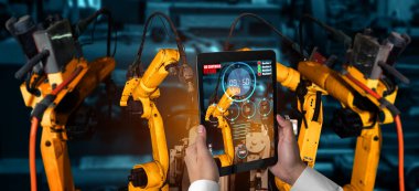 Mühendis, artırılmış gerçeklik endüstrisi teknolojisiyle robotik kolları kontrol ediyor.