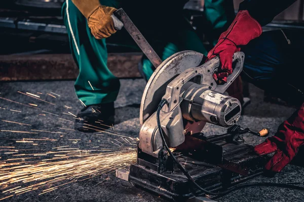 Professional mechanic man is cutting steel metal with rotating carbon blade — Stock Photo, Image