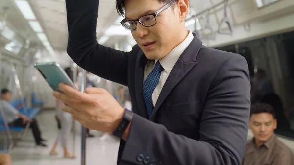 Бізнесмен, використовуючи мобільний телефон на громадському поїзді — стокове фото