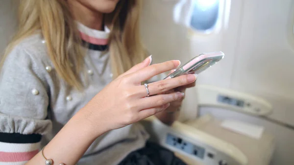 Aziatische vrouw met behulp van mobiele telefoon in het vliegtuig — Stockfoto