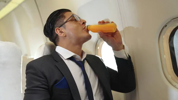 Businessman have orange juice served by an air hostess in airplane