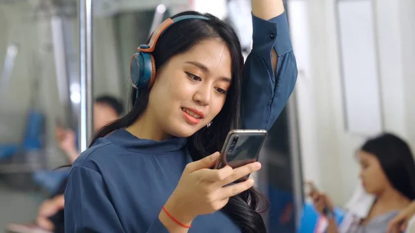 Jeune femme utilisant un téléphone portable dans le train public — Photo