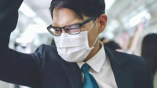 Young man wearing face mask travels on crowded subway train