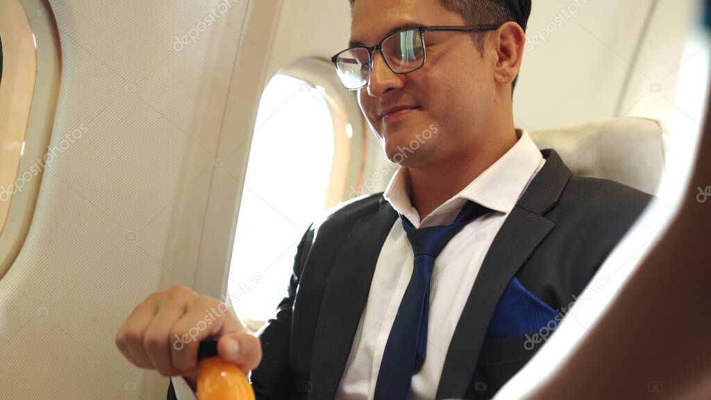 Businessman have orange juice served by an air hostess in airplane