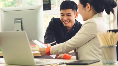 İki iş adamı ofiste proje stratejisi hakkında konuşuyor