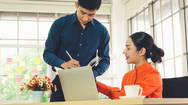 İki iş adamı ofiste proje stratejisi hakkında konuşuyor