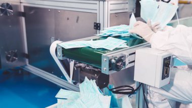 Modern fabrikada yüz maskesi üretim hattı