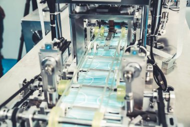 Modern fabrikada yüz maskesi üretim hattı