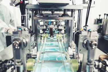 Modern fabrikada yüz maskesi üretim hattı