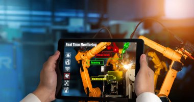 Mühendis, artırılmış gerçeklik endüstrisi teknolojisiyle robotik kolları kontrol ediyor.