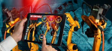 Mühendis, artırılmış gerçeklik endüstrisi teknolojisiyle robotik kolları kontrol ediyor.