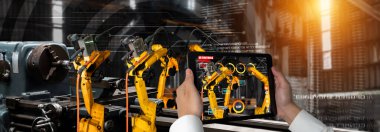 Mühendis, artırılmış gerçeklik endüstrisi teknolojisiyle robotik kolları kontrol ediyor.