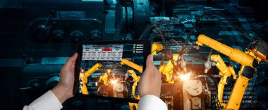 Mühendis, artırılmış gerçeklik endüstrisi teknolojisiyle robotik kolları kontrol ediyor.