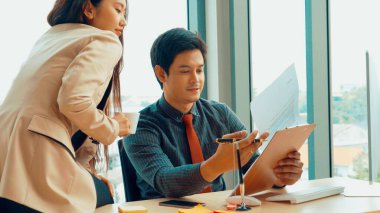 İki iş adamı ofiste proje stratejisi hakkında konuşuyor