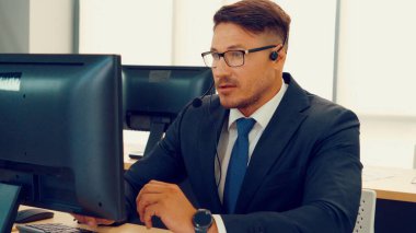 Ofiste çalışan kulaklık takan iş adamları.