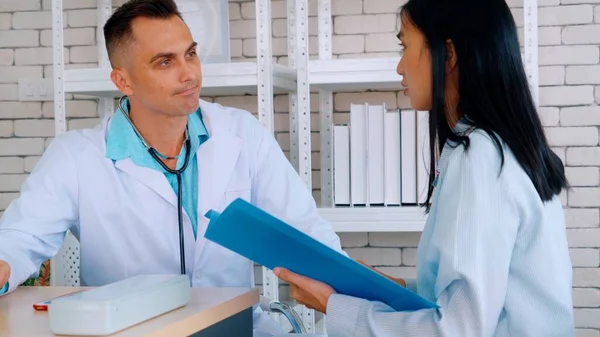 Doutor em uniforme profissional examinando paciente no hospital — Fotografia de Stock