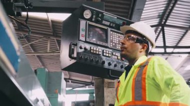 Fabrika atölyesinde makine kullanan akıllı bir fabrika işçisi