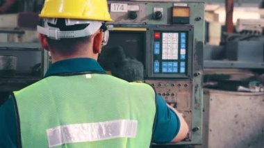 Fabrika atölyesinde makine ekipmanı kullanan bir grup işçi.