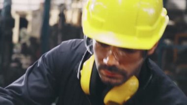 Fabrika atölyesinde makine kullanan akıllı bir fabrika işçisi