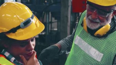 Fabrika atölyesinde makine ekipmanı kullanan bir grup işçi.
