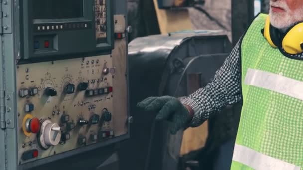 Trabajador principal de la fábrica enseña cómo utilizar el equipo de la máquina en el taller de fábrica — Vídeos de Stock