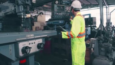 Fabrika atölyesinde makine kullanan akıllı bir fabrika işçisi