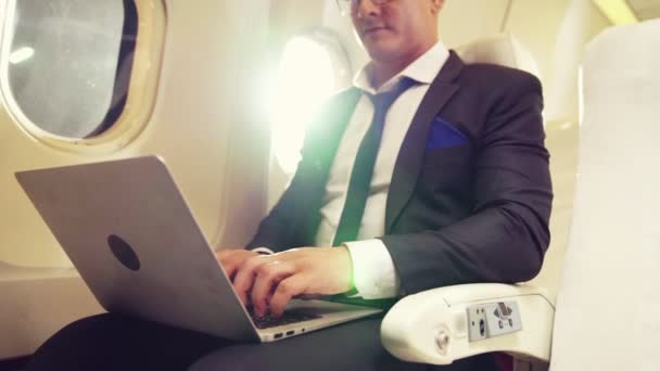 Jovem empresário usando computador portátil no avião — Vídeo de Stock