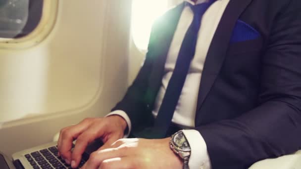 Giovane uomo d'affari che utilizza il computer portatile in aereo — Video Stock