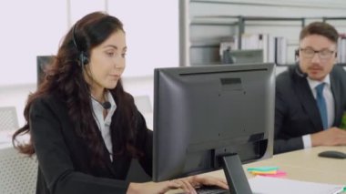 Ofiste çalışan kulaklık takan iş adamları.