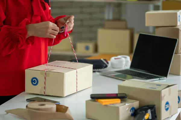 El vendedor en línea trabaja en la oficina de casa y empaca la caja de envío al cliente. — Foto de Stock