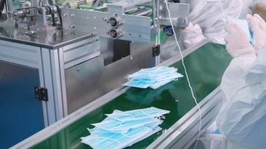 Modern fabrikada yüz maskesi üretim hattı