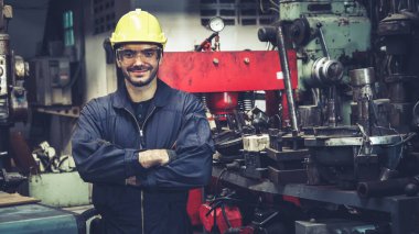 Genç bir fabrika işçisi ya da mühendis fabrikada portreyi kapatıyor.