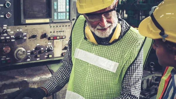 Fabrika atölyesinde makine ekipmanı kullanan bir grup işçi. — Stok fotoğraf