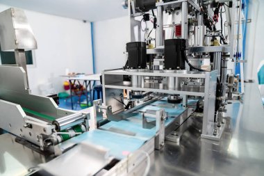 Modern fabrikada yüz maskesi üretim hattı