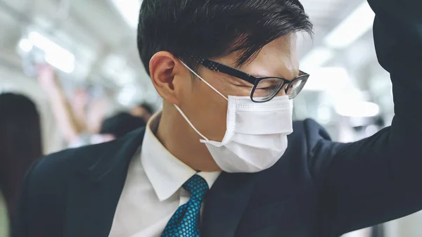 Junger Mann mit Gesichtsmaske fährt in überfüllter U-Bahn — Stockfoto